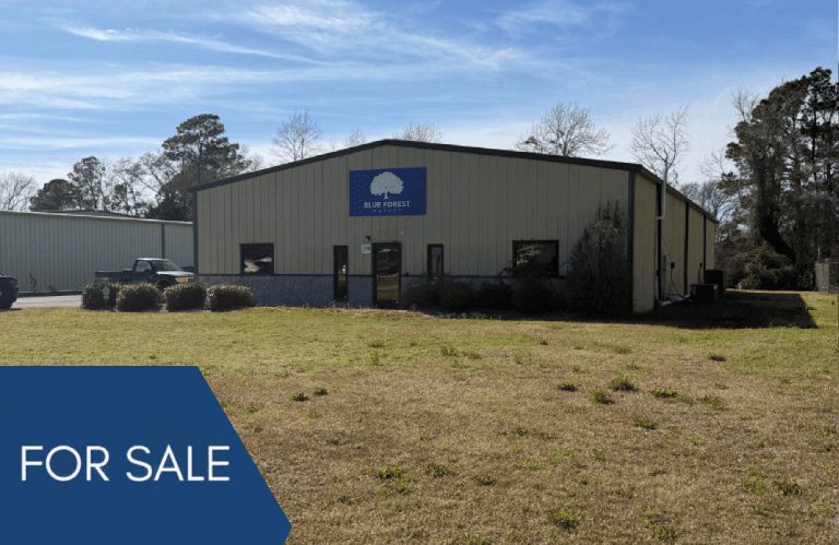 Commercial metal building with For Sale sign